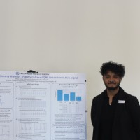 A student standing next to an ECG signal project.